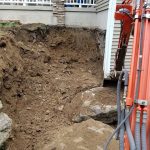 Excavator digging up wall